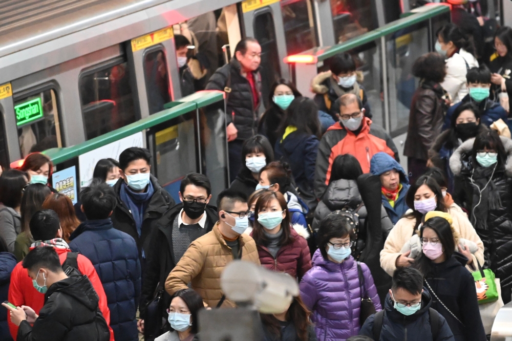 Mask-clad commuters get off a train at a Mass Rapid Transit (MRT) stop in Taipei following the Lunar New Year holidays on January 30, 2020. / AFP / Sam Yeh