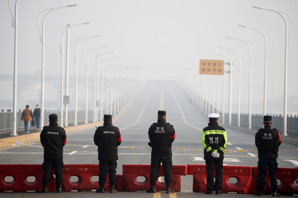 Police stand at a checkpoint at the Jiujiang Yangtze River Bridge that crosses from Hubei province in Jiujiang, Jiangxi province, China, as the country is hit by an outbreak of a new coronavirus, January 31, 2020