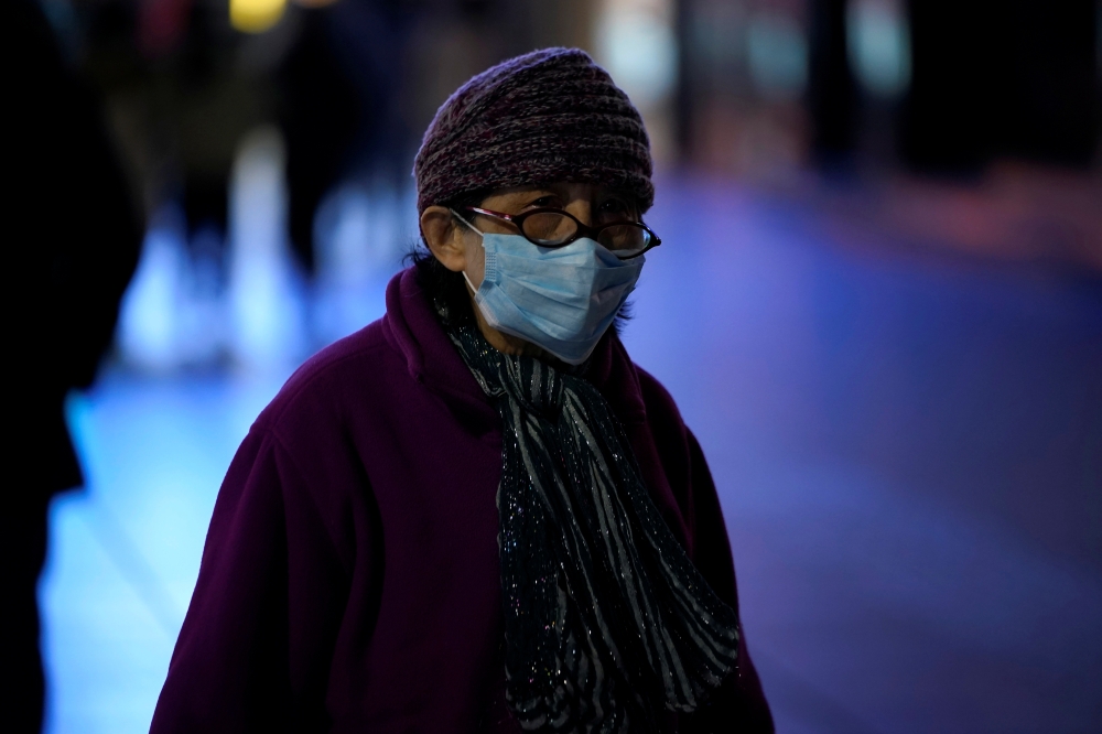 A woman wearing a mask is seen on a street in Shanghai, China January 31, 2020. REUTERS/Aly Song