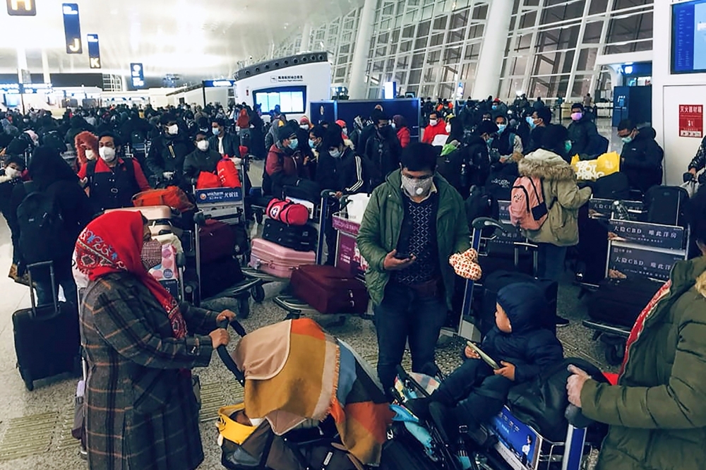 Bangladeshi citizens, mostly students, wearing facemasks wait at Wuhan airport on January 31, 2020, as the Bangladeshi government prepares to evacuate them following a SARS-like virus outbreak in the city of Wuhan. (AFP)