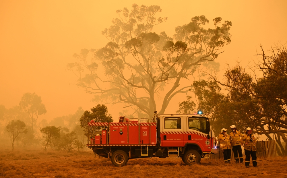 Firefighters protect property from bushfires burning near the town of Bumbalong south of Canberra on February 1, 2020. AFP / PETER PARKS