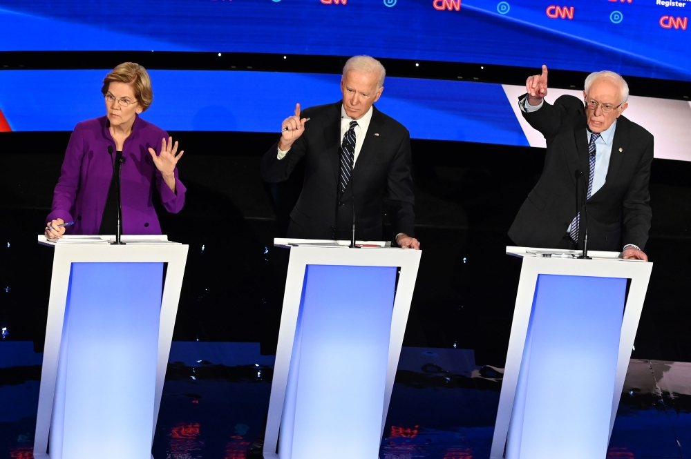(FILES) In this file photo taken on January 14, 2020 Democratic presidential hopefuls Massachusetts Senator Elizabeth Warren (L), former Vice President Joe Biden (C) and Vermont Senator Bernie Sanders participate in the seventh Democratic primary debate o