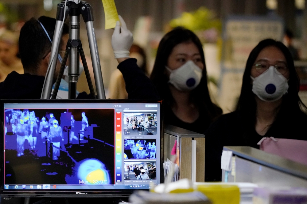 Passengers wearing masks to prevent contracting coronavirus walk past a thermal camera upon their arrival at Incheon International Airport in Incheon, South Korea, January 3, 2020. REUTERS/Kim Hong-Ji