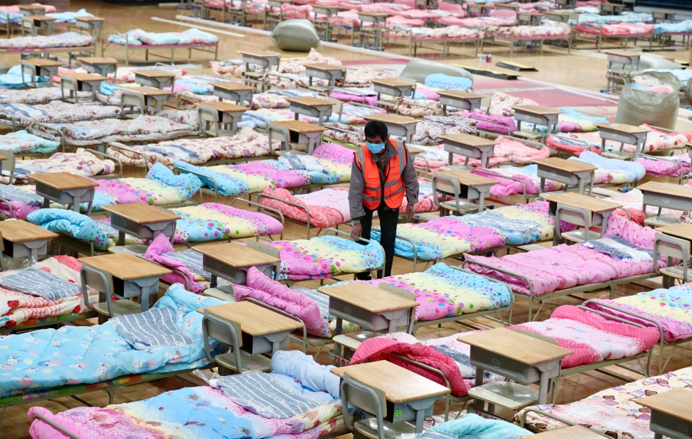 A worker sets up beds at the Hongshan Stadium to convert it into a makeshift hospital following an outbreak of the new coronavirus, in Wuhan, Hubei province, China February 4, 2020. China Daily via REUTERS 