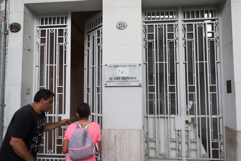 Maxi and his daughter Malena enter the building where they live and where Pope Francis was born in the district of Flores, in Buenos Aires, Argentina February 3, 2020.  Reuters/Matias Baglietto