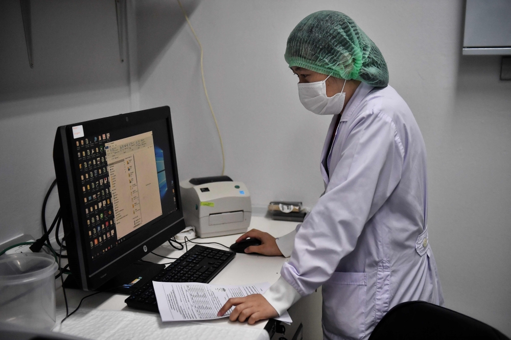 Lab technicians register samples from potential victims of the novel coronavirus at the Centre for Emerging Infectious Diseases of Thailand at Chulalongkorn University in Bangkok on February 5, 2020. / AFP / Lillian SUWANRUMPHA 