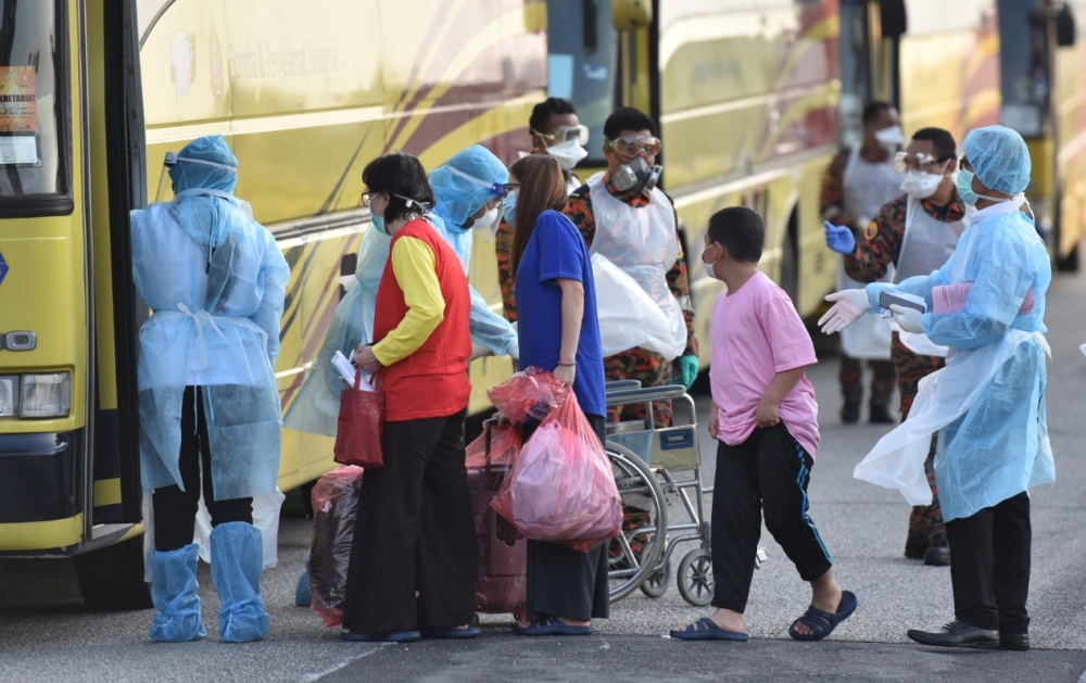  Evacuated Malaysian nationals from Wuhan, China are directed onto a bus by health officials in protective suits after arriving at Kuala Lumpur International Airport in Sepang, Malaysia, February 4, 2020. MalaysiaÕs Ministry of Health/Muzzafar Kasim/Hando