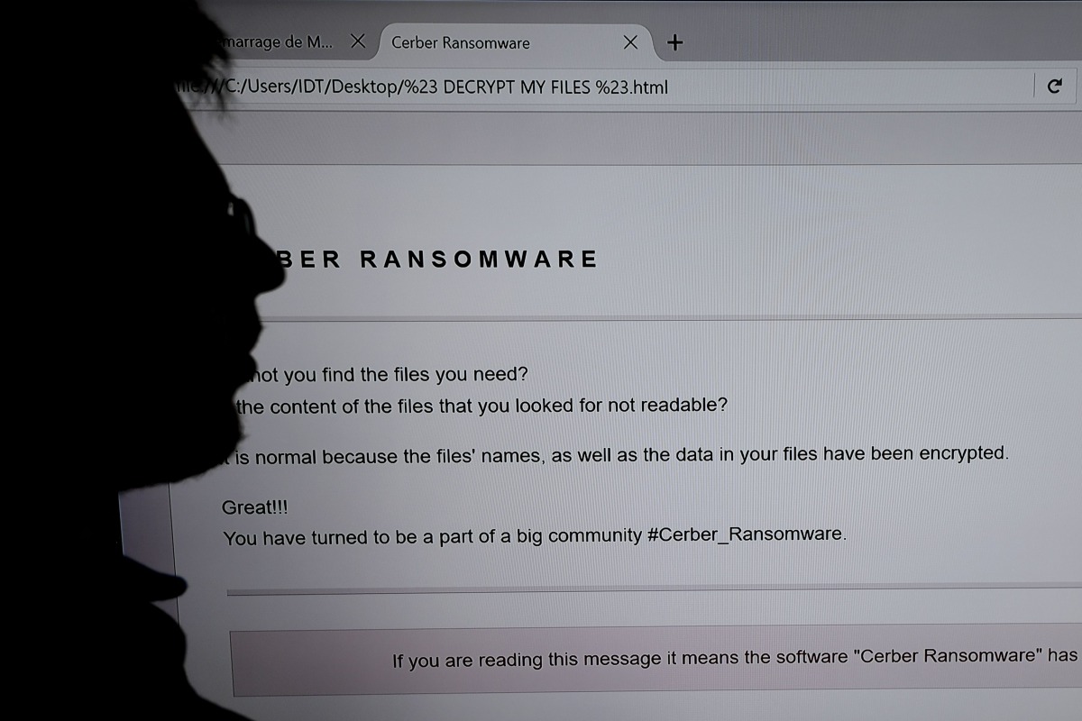 FILE PHOTO: An IT researcher stands next to a giant screen of a computer infected by a ransomware at the LHS of the INRIA in Rennes on November 3, 2016. AFP / Damien Meyer