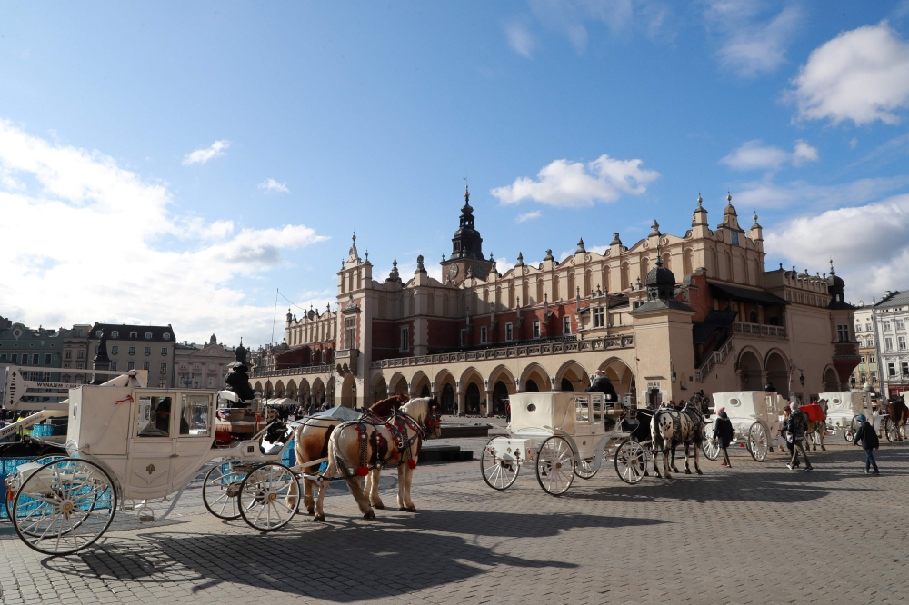 Horse carriages stand near the Cloth Hall building in the old city center in Krakow on Febuary 5, 2020. AFP / Ludovic Marin
 