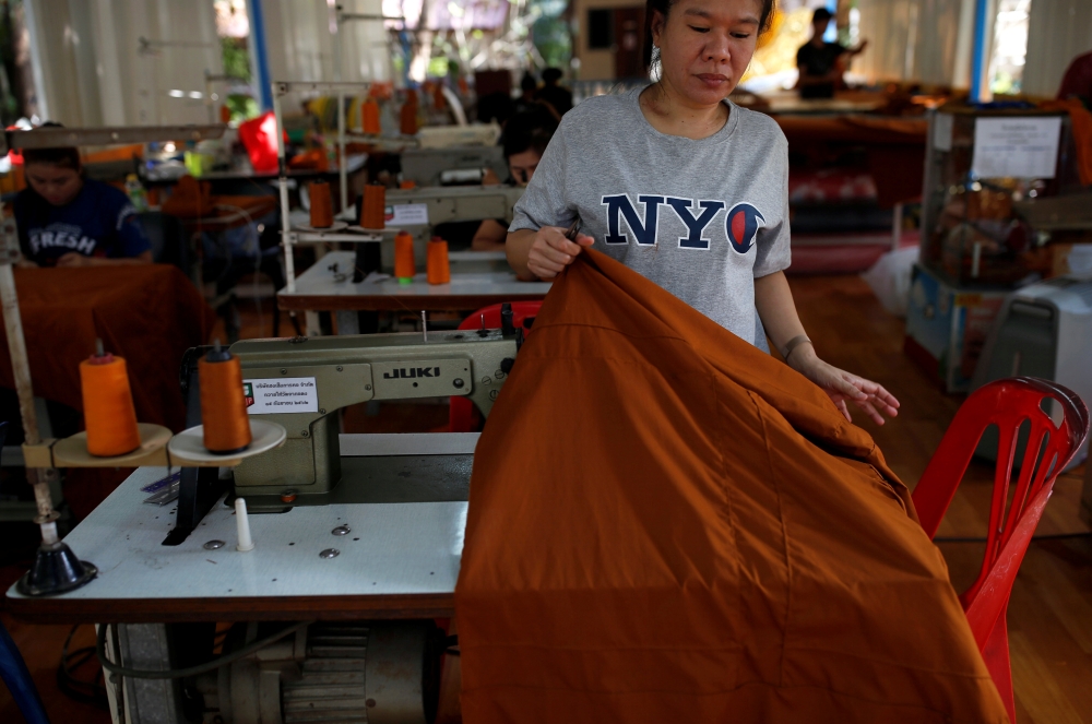 A woman sews a robe made of plastic bottles at a monastery in Bangkok, Thailand February 6, 2020. REUTERS/Soe Zeya Tun