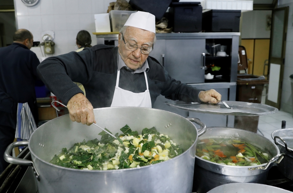Dino Impagliazzo, Rome's 90-year-old 'chef of the poor', stirs a saucepan of soup which he cooks for the homeless living in Rome and outside the Vatican colonnades, in Rome, Italy, January 18, 2020. Picture taken January 18, 2020. REUTERS/Remo Casilli