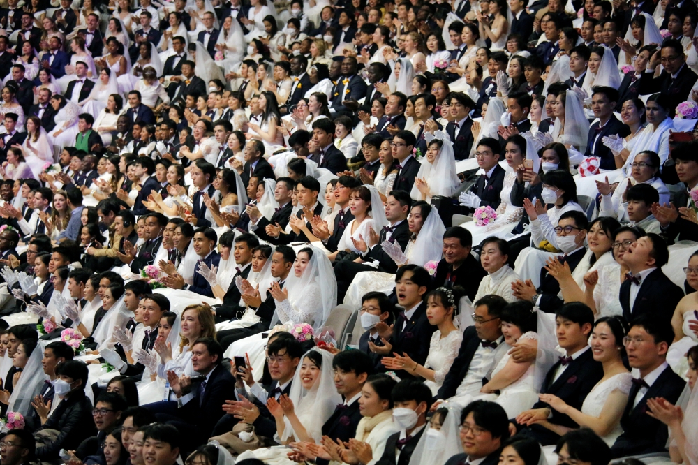 Couples wearing masks for protection from the new coronavirus, attend a mass wedding ceremony of the Unification Church at Cheongshim Peace World Centre in Gapyeong, South Korea, February 7, 2020. REUTERS/Heo Ran