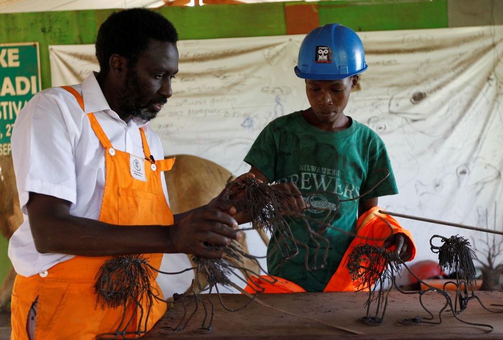 Kenyan metal sculptor Kioko Mwitiki and his student Kelvin Muia work on a metal sculpture at his art studio in Kisamis location of Kajiado, Kenya February 5, 2020. Picture taken February 5, 2020. REUTERS/Njeri Mwangi