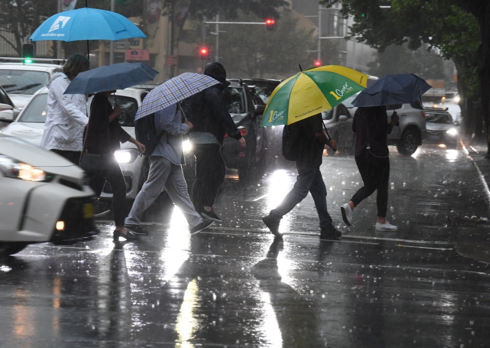 Pedestrians hold umbrellas during wet weather in Sydney, Australia, February 7, 2020. AAP Image/Peter Rae/via REUTERS