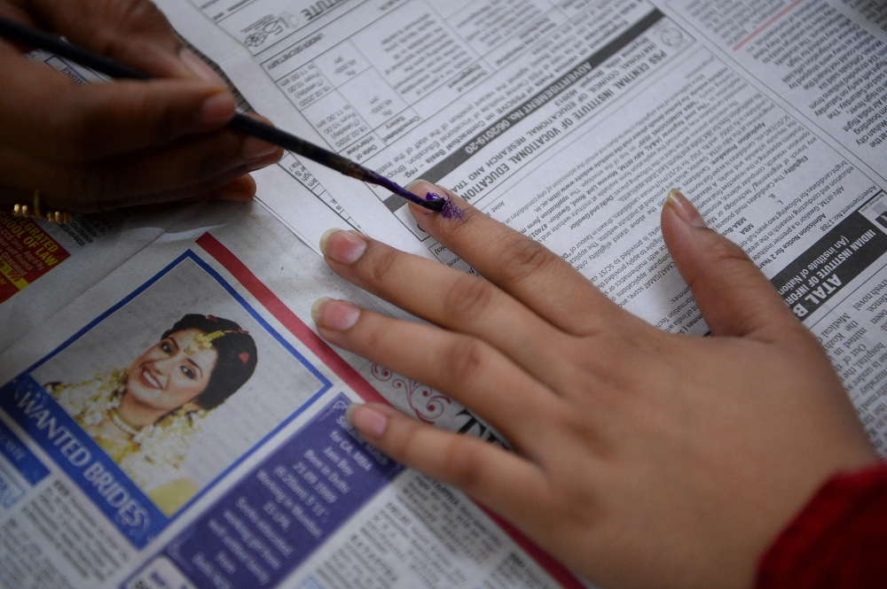 An election officer marks the finger of a voter at a polling station during the Legislative Assembly elections in New Delhi on February 8, 2020. / AFP / Sajjad HUSSAIN 