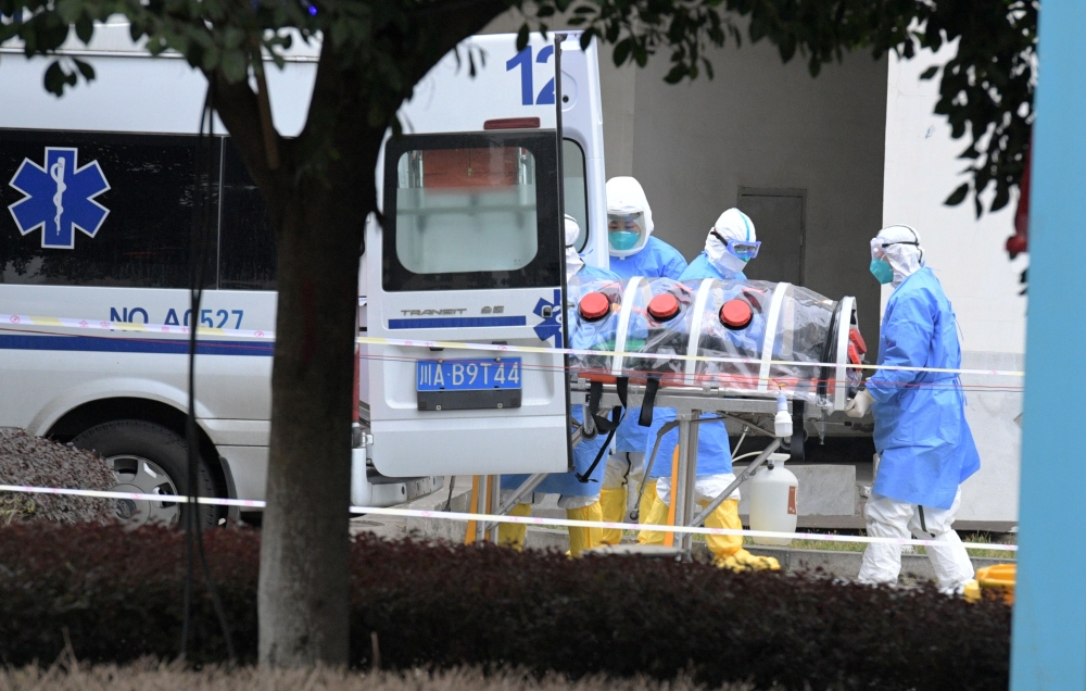 Medical workers in protective suits lift an isolated patient from an ambulance as the country is hit by an outbreak of the new coronavirus, in Chengdu, Sichuan province, China February 2, 2020. Picture taken February 2, 2020. cnsphoto via REUTERS ATTENTIO