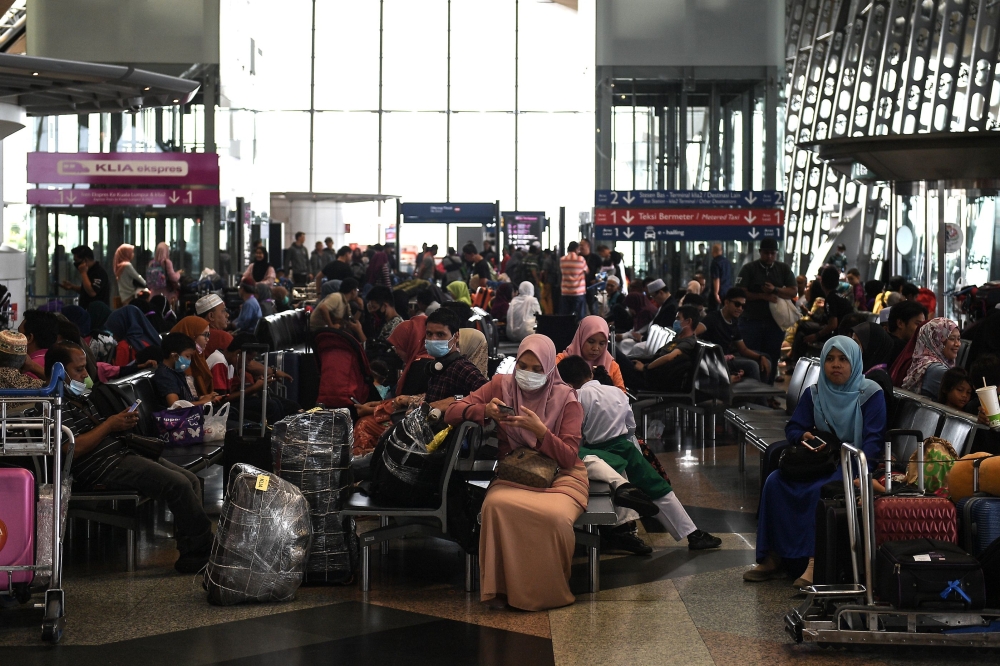  Passengers wear protective face masks at Kuala Lumpur International Airport in Sepang on February 4, 2020. / AFP / Mohd RASFAN
