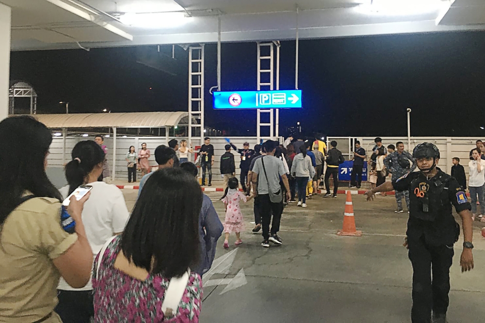 This handout from Chanathip Somsakul taken on February 8, 2020, and released to AFP on February 9, 2020 shows people in the carpark of the Terminal 21 shopping mall in Nakhon Ratchasima after they were evacuated following a shooting incident in the mall.