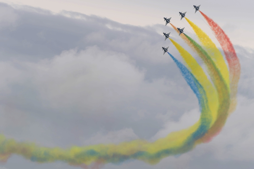 Members of the Chinese People's Liberation Army Air Force's Bayi Aerobatic Team fly J-10 performance aircraft as they take part in an aerial display during a media preview ahead of the Singapore Airshow in Singapore on February 9, 2020. / AFP / ROSLAN RAH