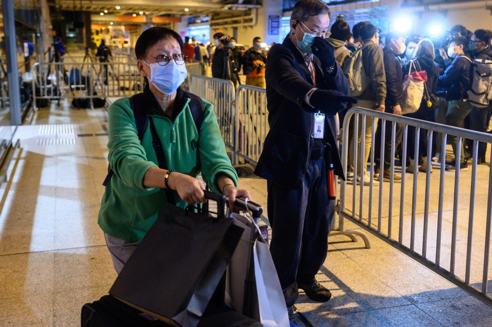 Passengers leave the World Dream cruise ship at the Kai Tak terminal in Hong Kong on February 9, 2020, where 3,600 people confined aboard for days as coronavirus checks was going. AFP / Philip Fong 
