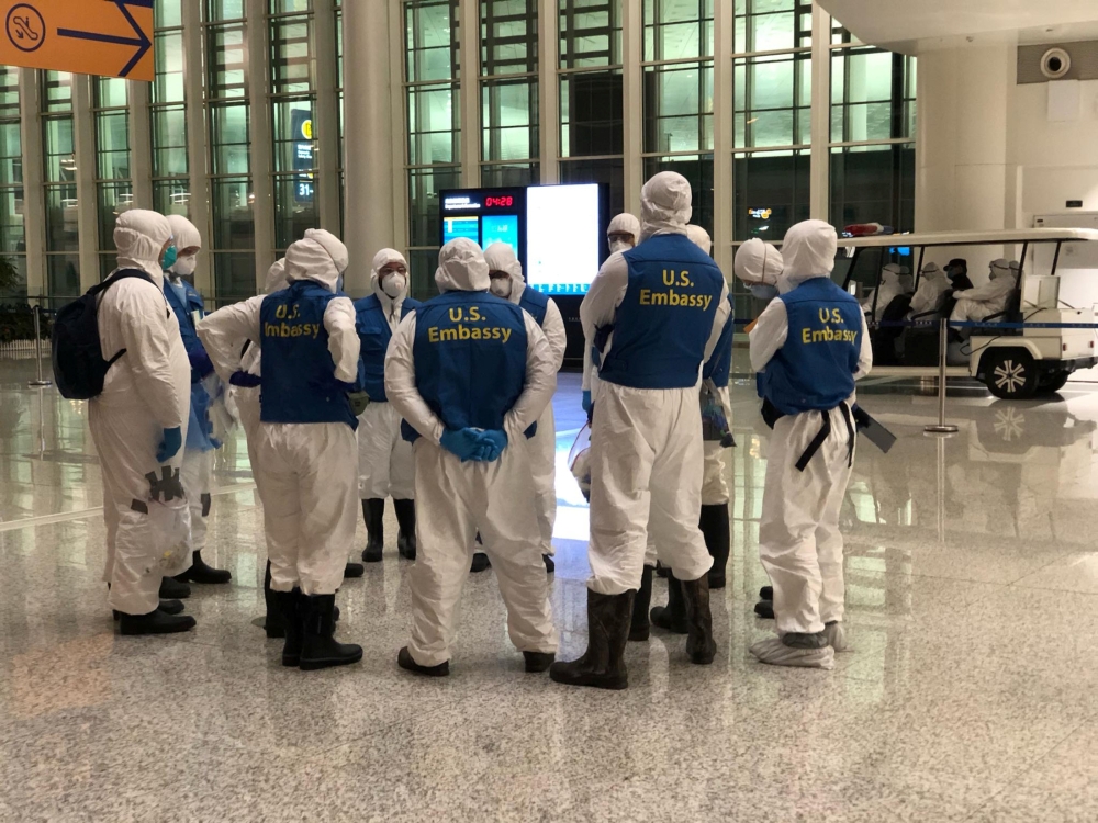 Staff from the US embassy assemble before inspecting a cargo plane, chartered by the US State Department to evacuate Americans and Canadians from China due to the outbreak of novel Coronavirus, at Wuhan Tianhe International Airport in Wuhan, China Februar