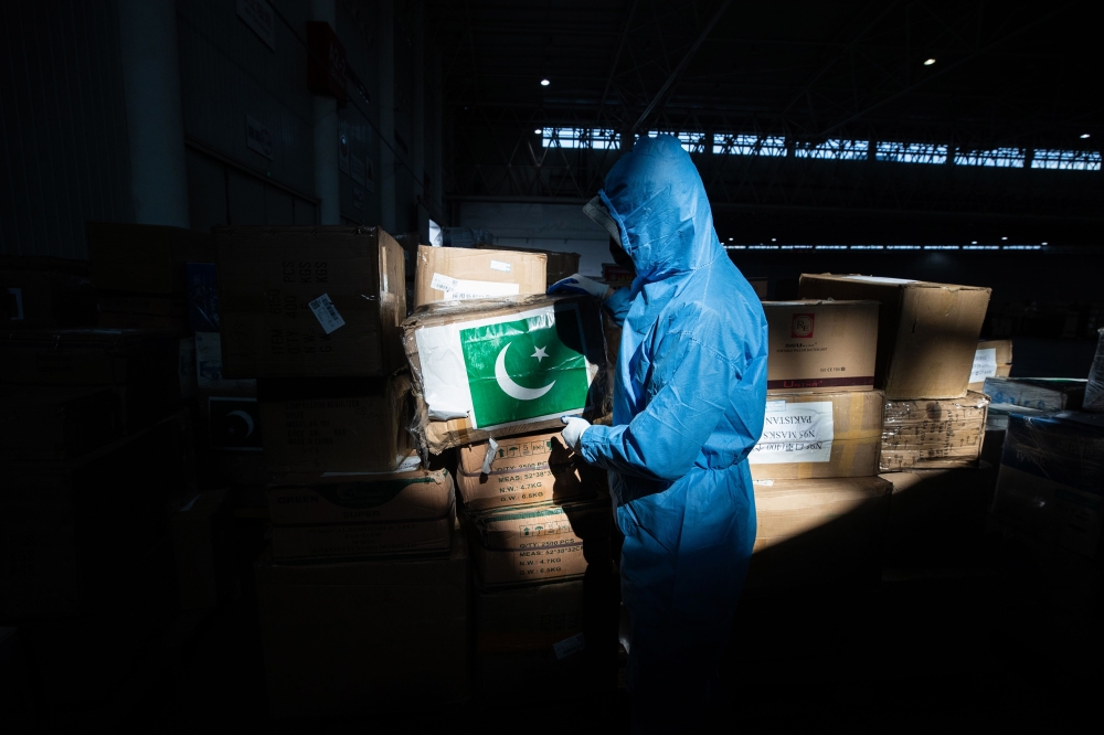 A staff member carrying a box of medical supplies from Pakistan at a warehouse of an exhibition centre which has been converted into a makeshift hospital in Wuhan, the epicentre of the new coronavirus outbreak, in China's central Hubei province on Februar