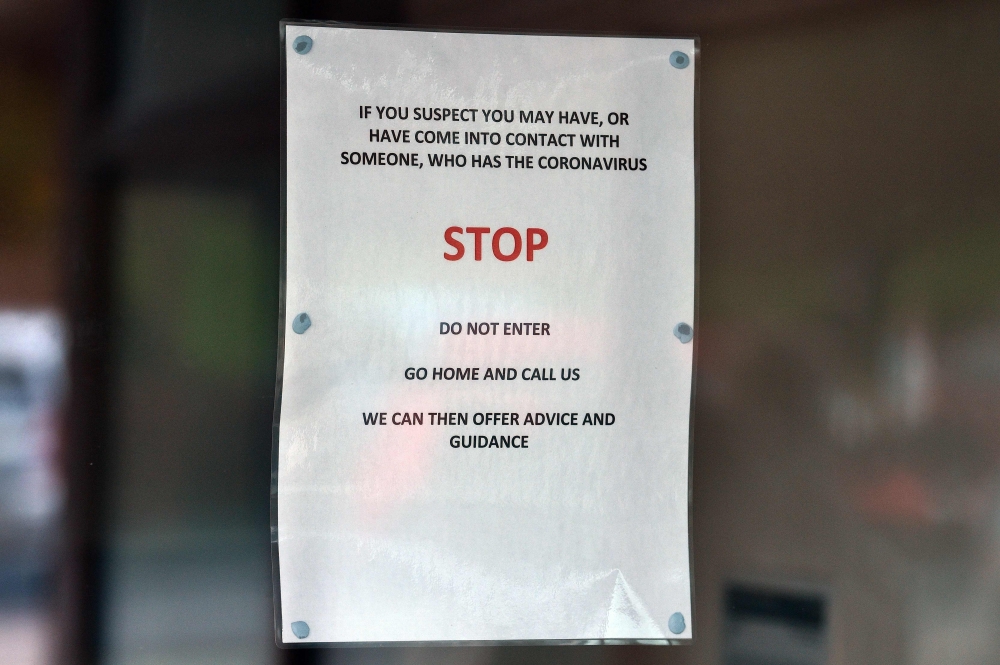 Signs warning patients about the 2019-nCoV strain of the novel coronavirus, are pictured at The County Oak Medical Centre in Brighton, Southern England on February 10, 2020, after it closed for 