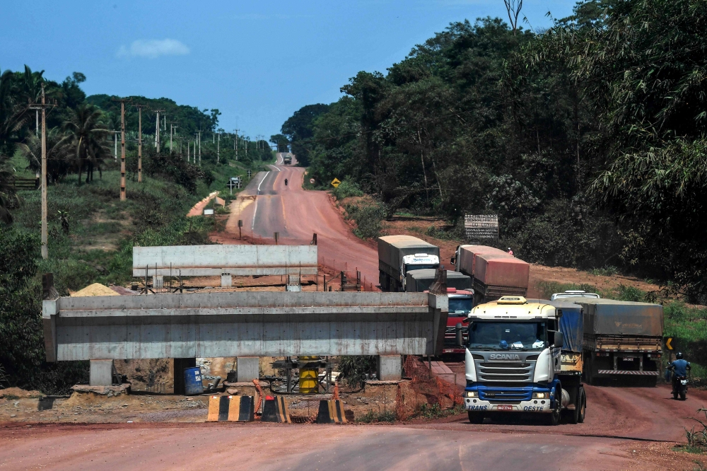 Trucks drive along the Trans-Amazonian highway BR230 past a bridge under construction, near Ruropolis, Para state, Brazil, in the Amazon rainforest, on September 7, 2019. AFP / Nelson Almeida