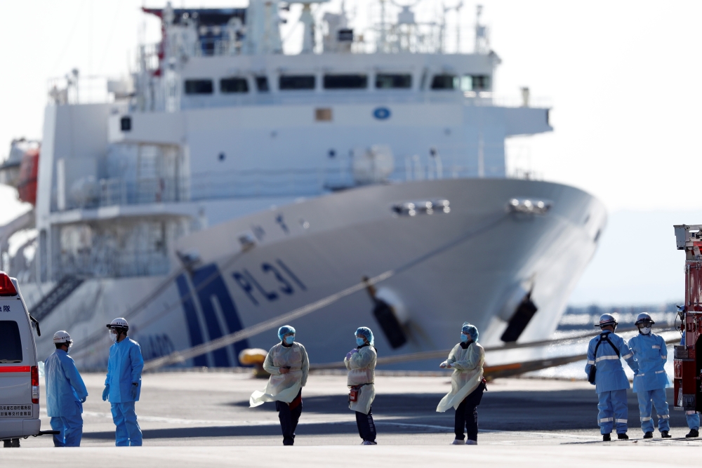 Medical personnel work near the cruise ship Diamond Princess, where dozens of passengers were tested positive for coronavirus, at Daikoku Pier Cruise Terminal in Yokohama, south of Tokyo, Japan, February 11, 2020. REUTERS/Issei Kato