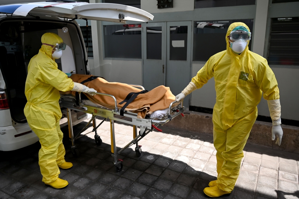 Health workers wearing protective gear take part in an exercise in handling a suspected patient at Sanglah hopital in Denpasar, Indonesia's resort island of Bali, on February 12, 2020. The number of fatalities from China's COVID-19 coronavirus epidemic ju