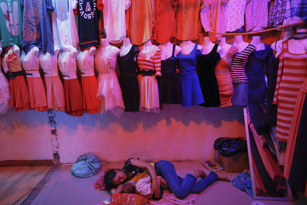 A garment worker Phnom Penh, Cambodia, sleeps on her factory.  Reuters / Damir Sagolj
 