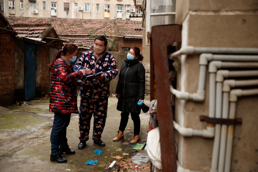 Members of a neighbourhood committee register a local and ask about his travel history in Jiujiang, Jiangxi province, China as the country is hit by coronavirus, February 2, 2020. Reuters / Thomas Peter