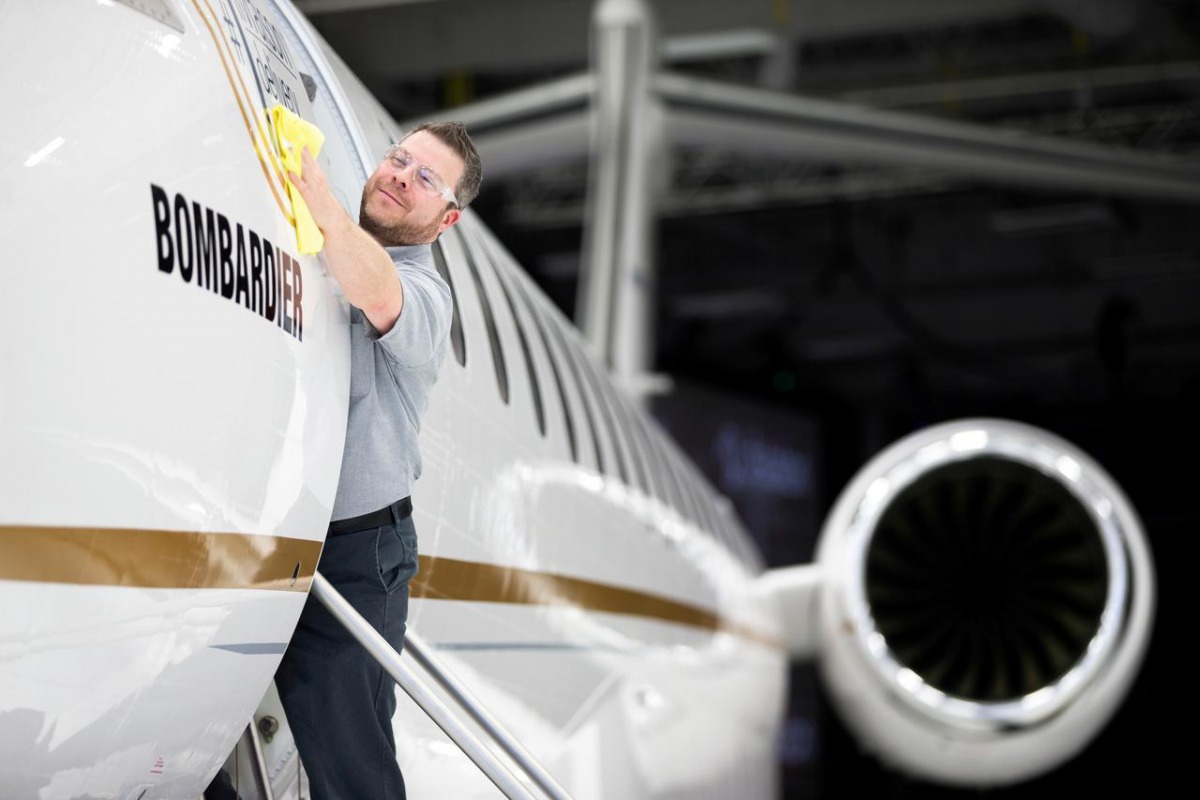 Bombardier employee Francis Masse polishes the sign of Bombardier Global 7500 shown during a media tour in Montreal, December 19, 2018. Reuters / Christinne Muschi