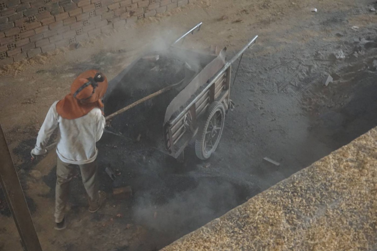 A boy shovels smoldering ash out of a kiln at a brick factory in Kandal Province, Cambodia, on January 23, 2020. Thomson Reuters Foundation/Matt Blomberg