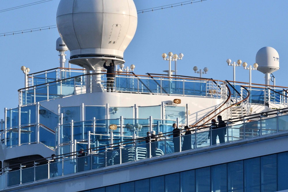 Passengers are seen on the deck of the Diamond Princess cruise ship, with around 3,600 people quarantined onboard due to fears of the new coronavirus, at the Daikaku Pier Cruise Terminal in Yokohama port on February 13, 2020. AFP / Kazuhiro Nogi 