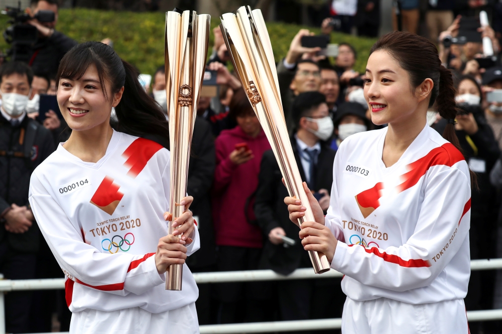Acting torchbearer and Actress Satomi Ishihara (R), one of the Official Ambassadors of the Tokyo 2020 Torch Relay pose with the olympic torch during a rehearsal as part of the Tokyo 2020 Olympic Torch Relay in Hamura, outskirts of Tokyo, Japan February 15