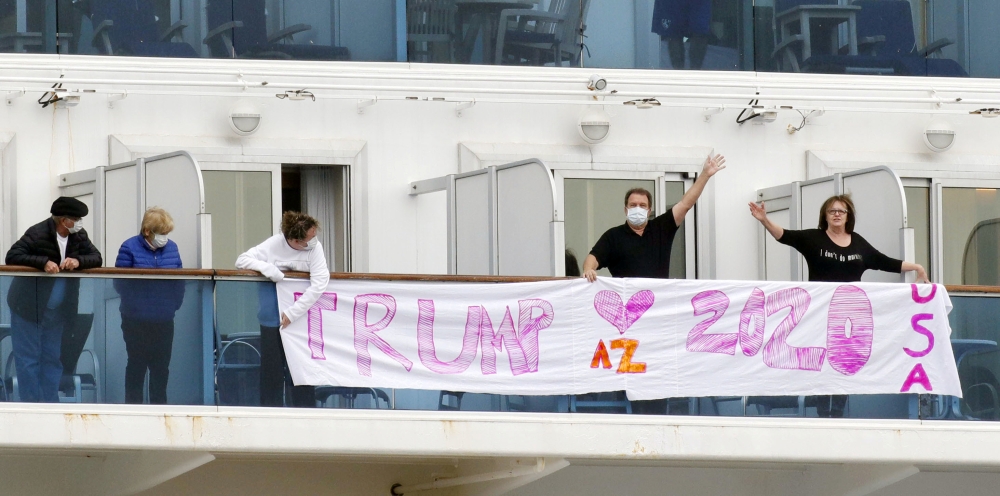 Passengers display a banner reading 'Trump 2020' on the deck of the cruise ship Diamond Princess, where dozens of passengers were tested positive for coronavirus, at Daikoku Pier Cruise Terminal in Yokohama, south of Tokyo, Japan, in this photo taken by K