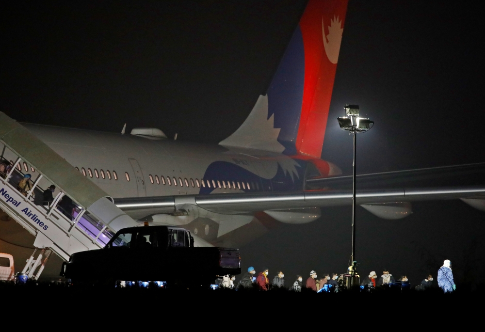 Nepalese nationals who were in the coronavirus-stricken Chinese city of Wuhan walk out from a Nepal Airlines plane carrying 175 Nepalese nationals, before they were sent to be quarantine, at Tribhuvan International Airport in Kathmandu, Nepal February 16,