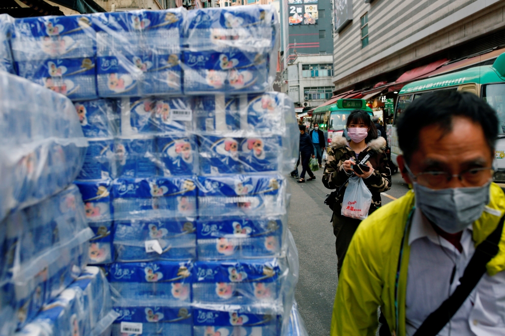 People wear masks as they walk past rolls of toilet paper at a market, following the outbreak of a new coronavirus, in Hong Kong. (REUTERS/Tyrone Siu/File Photo)