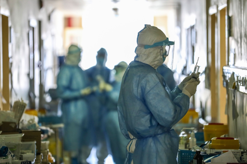 This photo taken on February 16, 2020 shows medical staff members working at the isolation ward of the Wuhan Red Cross Hospital in Wuhan in China's central Hubei province./ AFP / STR 