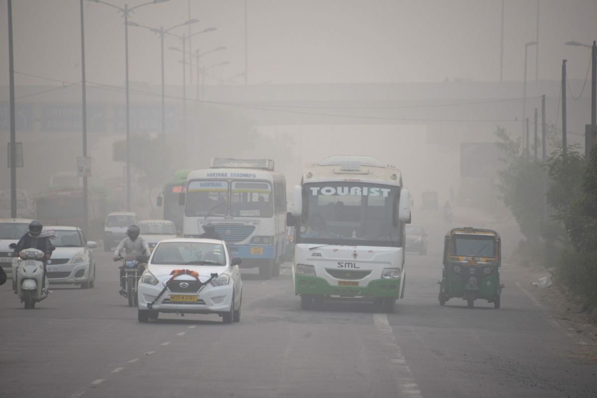 In this photograph taken on November 7, 2016 Indian commuters journey along a major road as heavy smog covers New Delhi. AFP