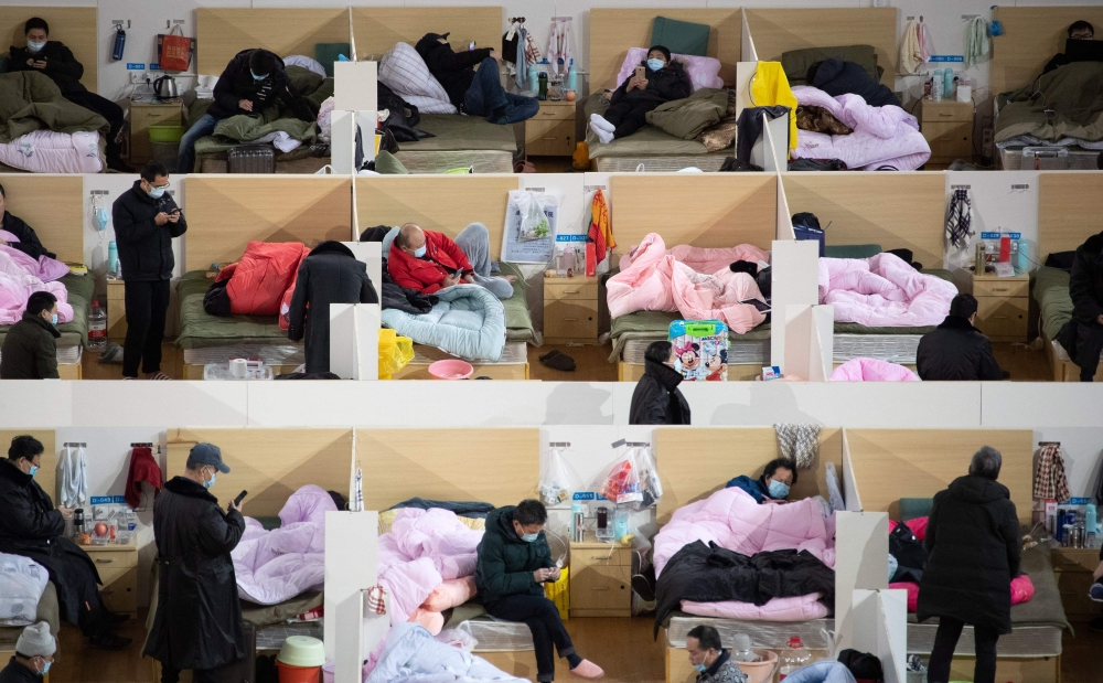 Patients with mild symptoms of the COVID-19 coronavirus resting at night in the temporary Fangcai Hospital set up in a sports stadium in Wuhan, in China's central Hubei province February 18, 2020.  AFP 
 