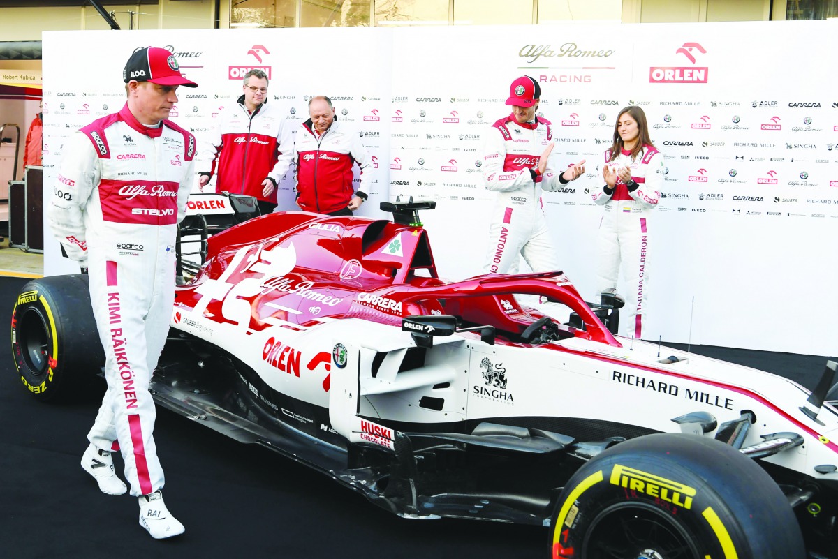 Alfa Romeo's Finnish driver Kimi Raikkonen (L) and Alfa Romeo's Italian driver Antonio Giovinazzi (2R) pose with the new Alfa Romeo Racing C39 Formula One car at the Circuit de Barcelona-Catalunya in Montmelo in the outskirts of Barcelona on February 19, 