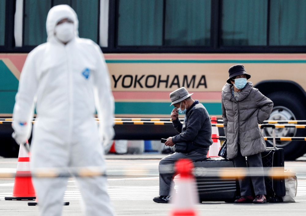 Passengers wait for transportation after leaving the coronavirus-hit Diamond Princess cruise ship docked at Yokohama Port, south of Tokyo, Japan, February 20, 2020. REUTERS/Kim Kyung-Hoon 