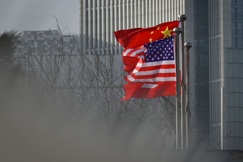 (FILES) In this file photo taken on January 19, 2020, Chinese and US national flags flutter at the entrance of a company office building in Beijing.  AFP / WANG ZHAO