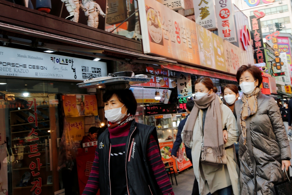 Women wearing masks as a preventive measure against the coronavirus walk at a traditional market in Seoul, South Korea, February 20, 2020. REUTERS/Heo Ran 