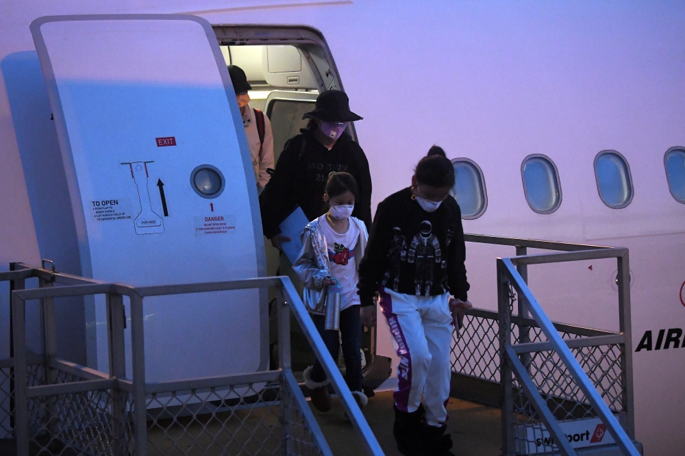 Australian evacuees who were quarantined on Christmas Island over concerns about the coronavirus disembark from a plane at Sydney Airport in Sydney, Australia, February 17, 2020. Picture taken February 17, 2020. AAP Image/Steven Saphore/via REUTERS