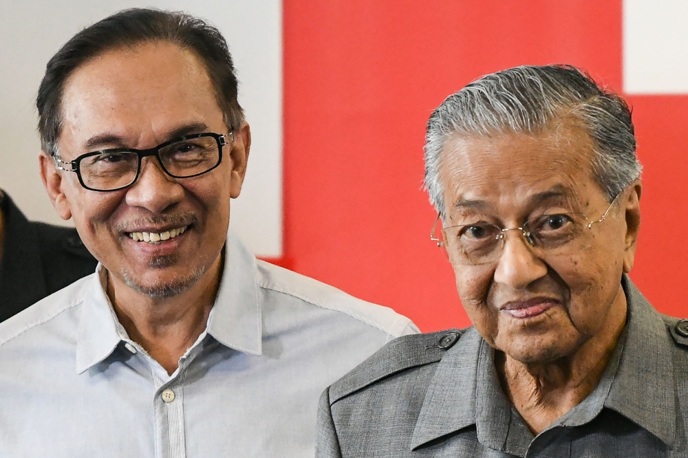 In this file photo taken on June 1, 2018, Malaysia's Prime Minister Mahathir Mohamad (R) and politician Anwar Ibrahim leave after a press conference in Kuala Lumpur. / AFP / Mohd RASFAN 