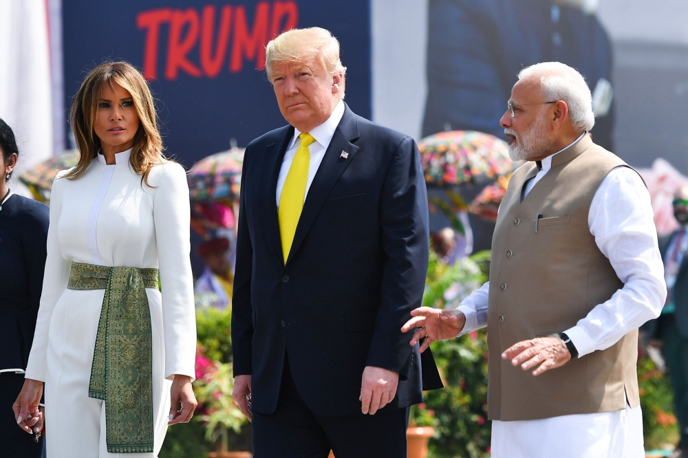 India's Prime Minister Narendra Modi (R) speaks with US President Donald Trump (C) and First Lady Melania Trump (L) upon their arrival at Sardar Vallabhbhai Patel International Airport in Ahmedabad on February 24, 2020. / AFP / Mandel NGAN 