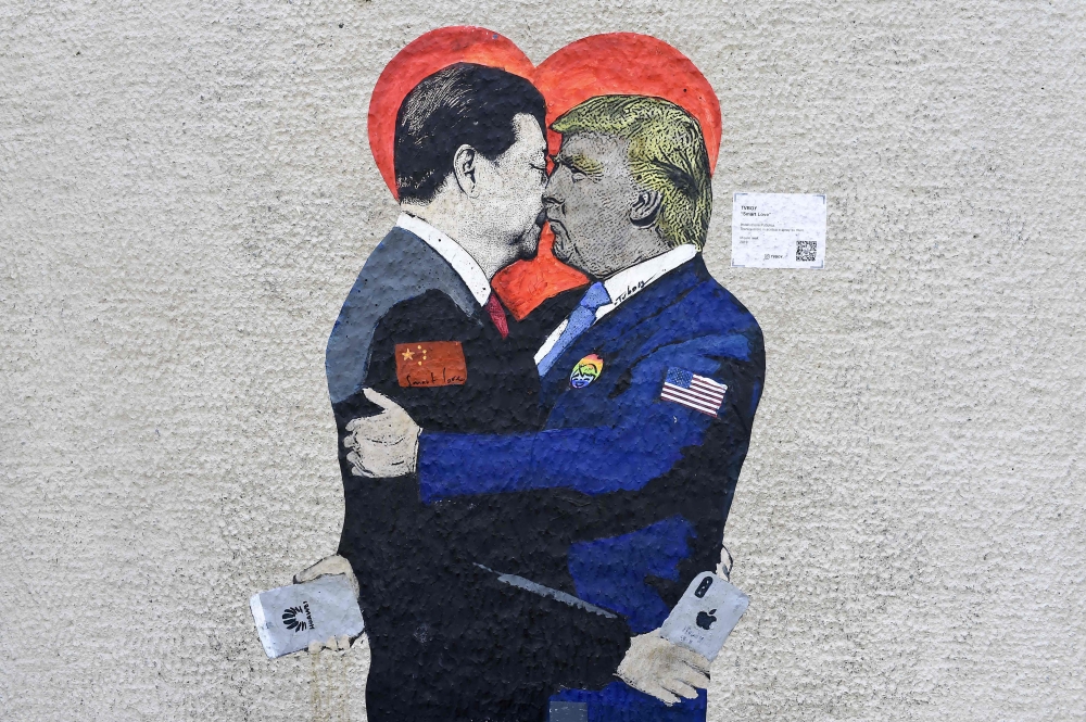 ‘Smart Love’ mural by Italien street artist TvBoy depicts Xi Jinping, holding an i-Phone smartphone kissing US President Donald Trump, holding an Huawei smartphone in Milan on June 29, 2019. AFP / Miguel Medina